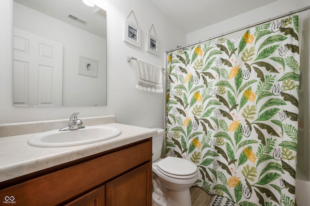 bathroom featuring a shower with shower curtain, vanity, and toilet