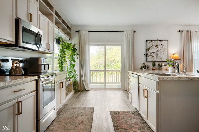 kitchen with light hardwood / wood-style floors, white cabinetry, sink, and stainless steel appliances