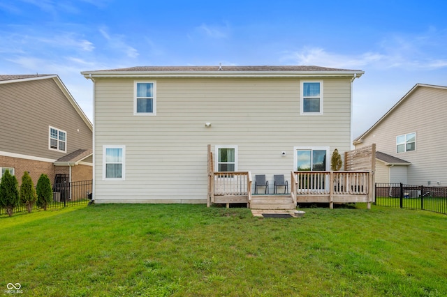 rear view of house with a wooden deck and a lawn