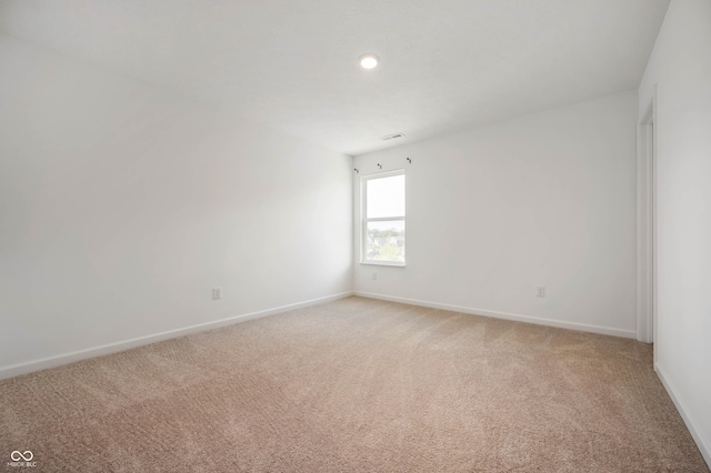 spare room featuring light colored carpet