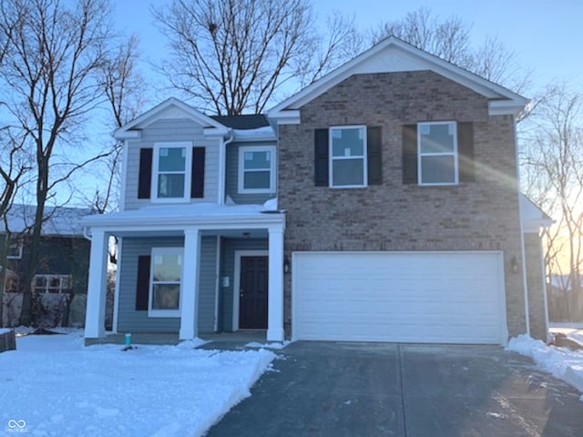 view of front of home with a garage, concrete driveway, and brick siding