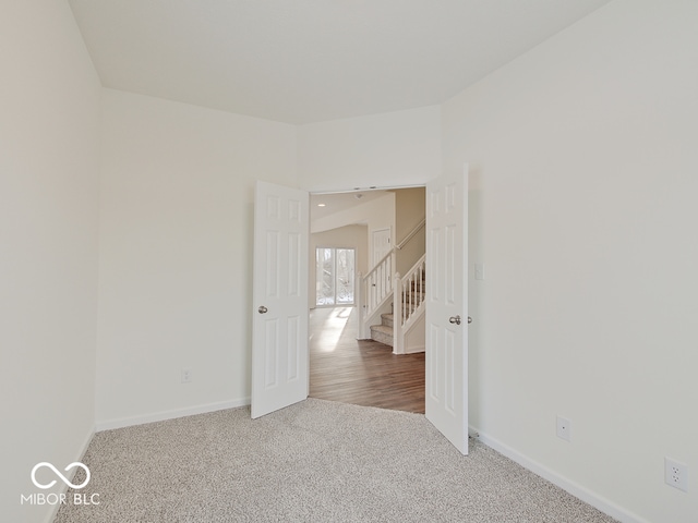 spare room featuring carpet and baseboards