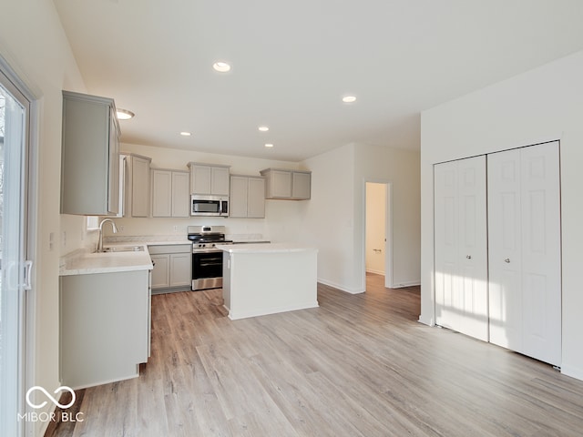 kitchen with gray cabinetry, appliances with stainless steel finishes, light countertops, and a center island