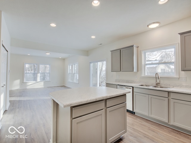 kitchen featuring open floor plan, light countertops, a sink, and dishwasher