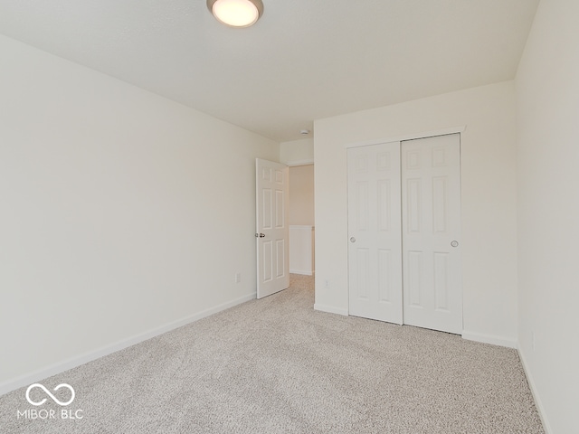 unfurnished bedroom featuring carpet, a closet, and baseboards