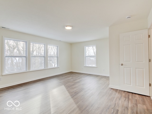 unfurnished room featuring light wood finished floors, baseboards, and visible vents