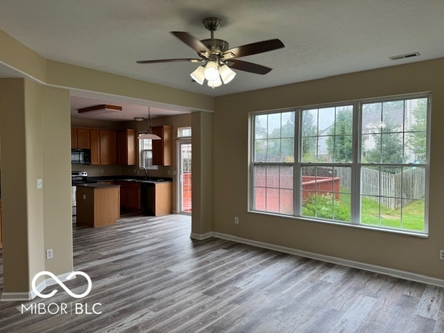 kitchen with pendant lighting, ceiling fan, hardwood / wood-style flooring, and sink