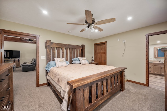 bedroom featuring ceiling fan, light colored carpet, connected bathroom, and sink