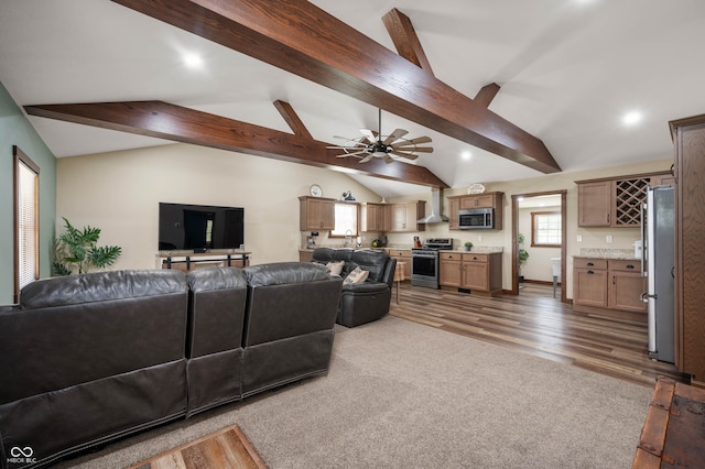 living room with lofted ceiling with beams, ceiling fan, dark wood-type flooring, and sink