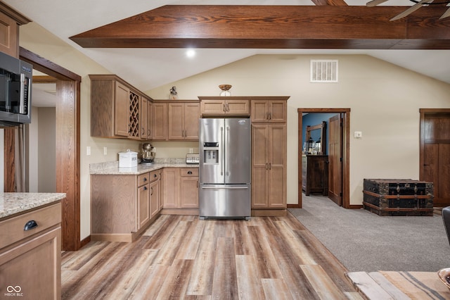 kitchen featuring lofted ceiling, light stone countertops, ceiling fan, and stainless steel appliances