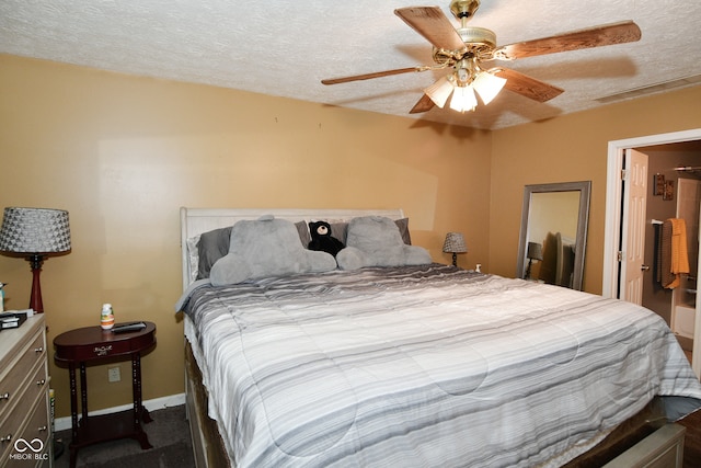 carpeted bedroom with ceiling fan and a textured ceiling