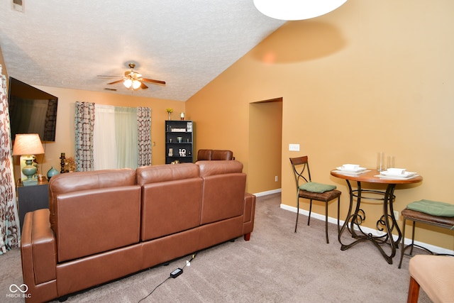 living room with a textured ceiling, carpet flooring, vaulted ceiling, and ceiling fan