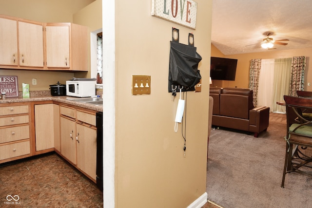 kitchen with dark carpet, ceiling fan, light brown cabinets, and a textured ceiling