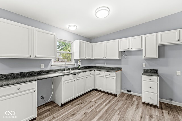 kitchen with light hardwood / wood-style floors, sink, and white cabinets