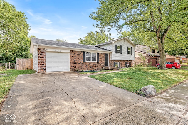 tri-level home with a garage and a front lawn