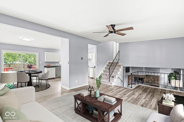 living room featuring ceiling fan and light hardwood / wood-style floors