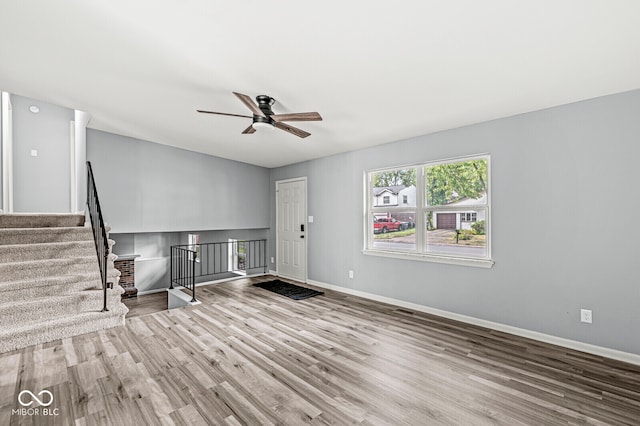 unfurnished living room featuring ceiling fan and light wood-type flooring