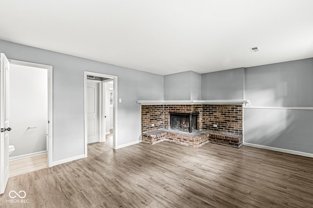 unfurnished living room featuring hardwood / wood-style flooring and a fireplace