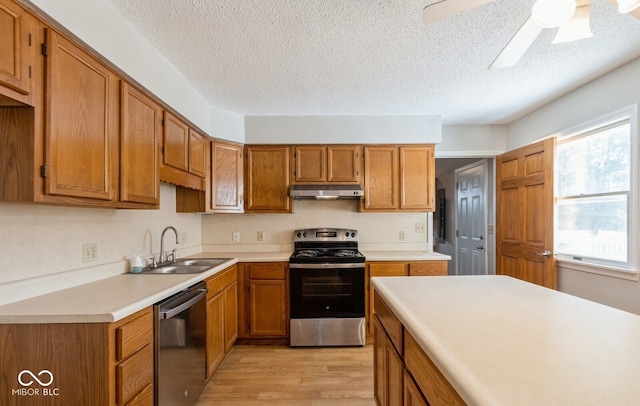 kitchen with a textured ceiling, sink, light hardwood / wood-style flooring, appliances with stainless steel finishes, and ceiling fan