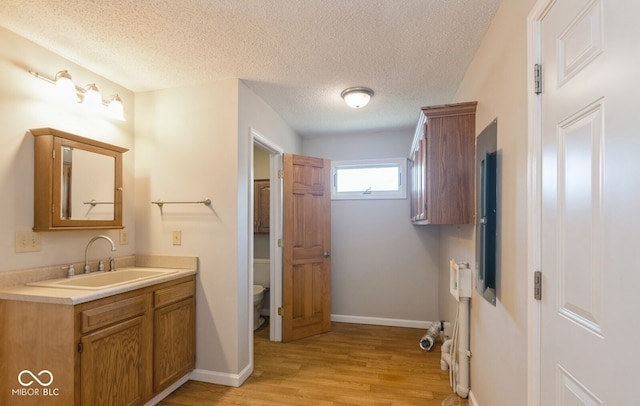 bathroom with vanity, hardwood / wood-style floors, toilet, and a textured ceiling