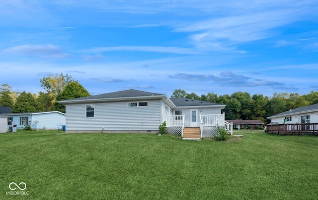 rear view of house with a lawn and a wooden deck