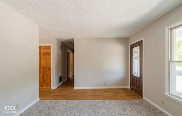 entryway featuring a textured ceiling and light hardwood / wood-style floors