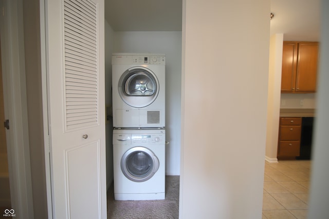 washroom featuring light tile patterned floors and stacked washer and clothes dryer