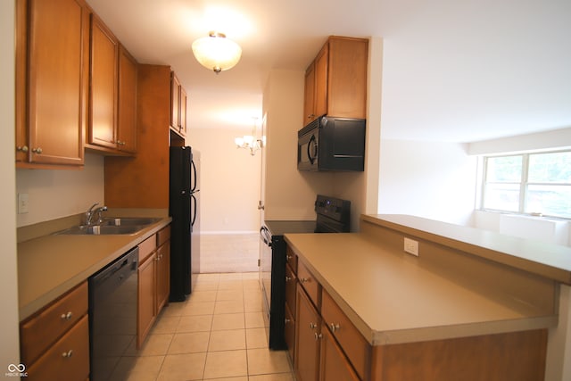 kitchen featuring light tile patterned floors, sink, kitchen peninsula, and black appliances