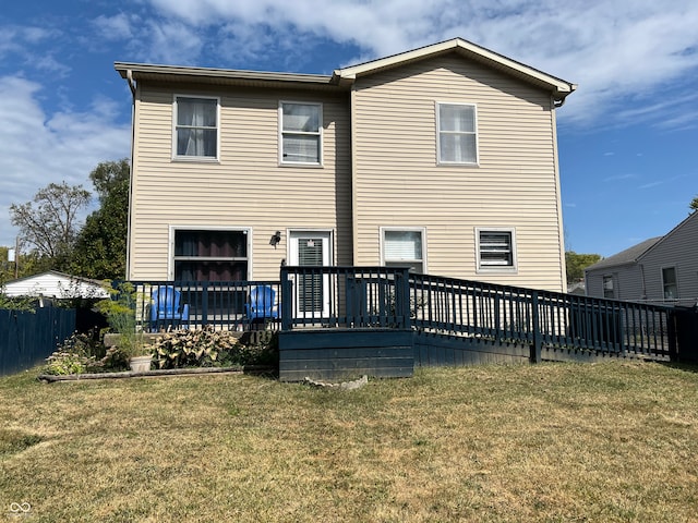 back of property featuring a wooden deck and a lawn