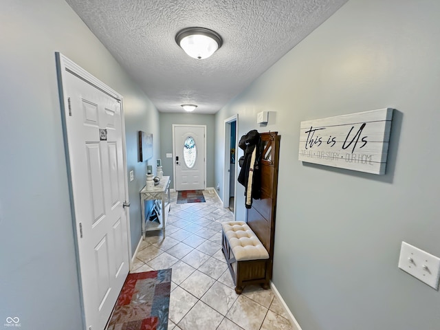 interior space featuring a textured ceiling and light tile patterned floors