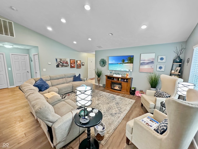 living room with light wood-type flooring and lofted ceiling