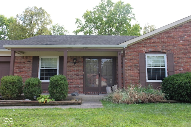 view of exterior entry featuring a lawn and french doors