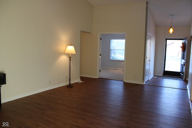 entryway with a towering ceiling and dark hardwood / wood-style flooring