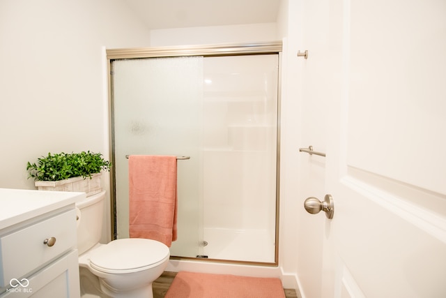 bathroom featuring vanity, toilet, and an enclosed shower