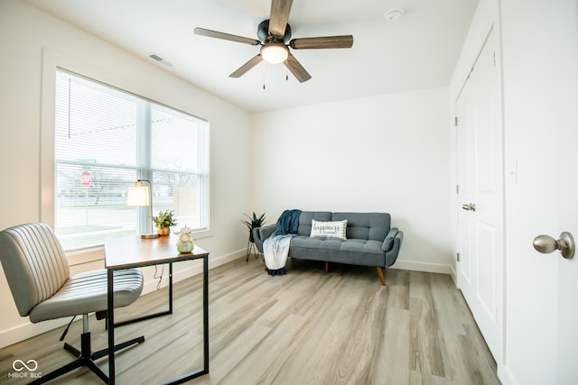 living area featuring light hardwood / wood-style flooring and ceiling fan