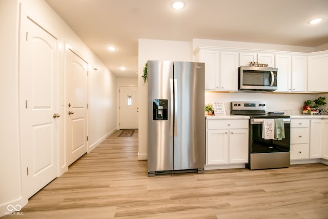 kitchen featuring white cabinets, stainless steel appliances, and light hardwood / wood-style floors