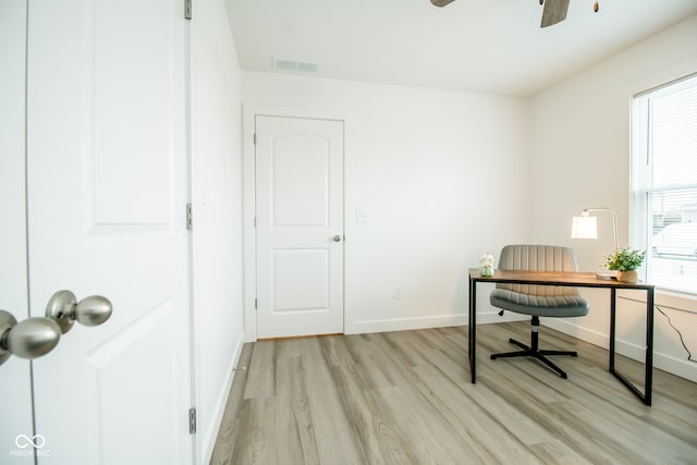 home office with light hardwood / wood-style flooring and ceiling fan