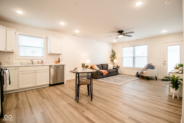 kitchen featuring dishwasher, sink, ceiling fan, light wood-type flooring, and white cabinetry