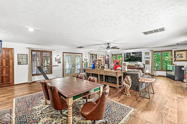 dining area featuring light hardwood / wood-style flooring, ceiling fan, french doors, and a wealth of natural light