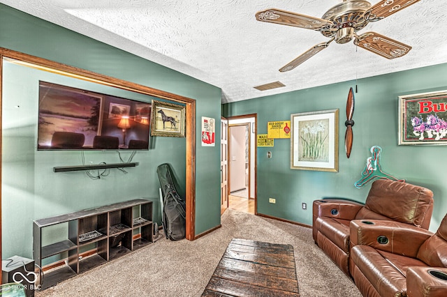 living room featuring a textured ceiling, ceiling fan, and light colored carpet