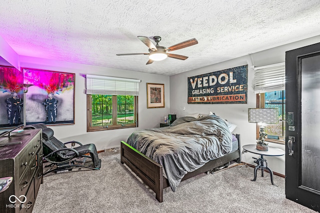 bedroom featuring ceiling fan, carpet floors, and a textured ceiling