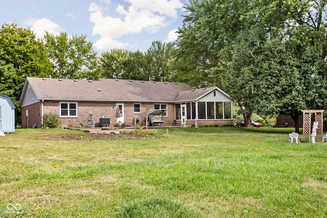 rear view of property with a lawn, a sunroom, and central air condition unit