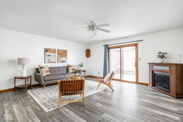 living room with a textured ceiling, light hardwood / wood-style flooring, and ceiling fan