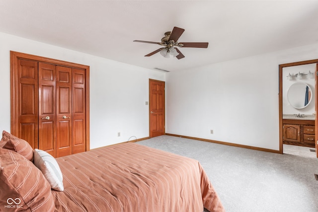 bedroom featuring sink, light colored carpet, ceiling fan, and ensuite bath