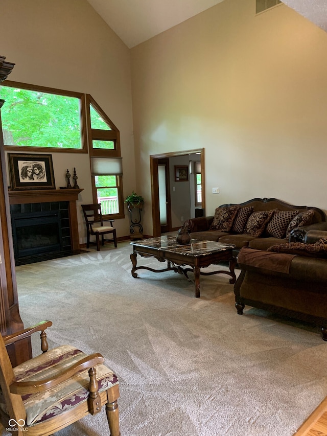 carpeted living room with a fireplace and high vaulted ceiling