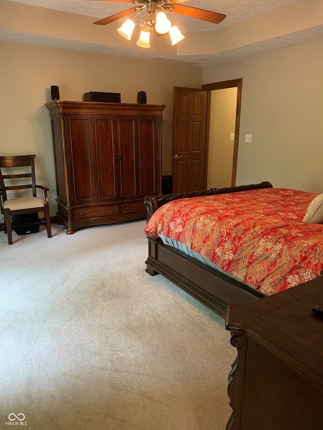 carpeted bedroom featuring a textured ceiling and ceiling fan