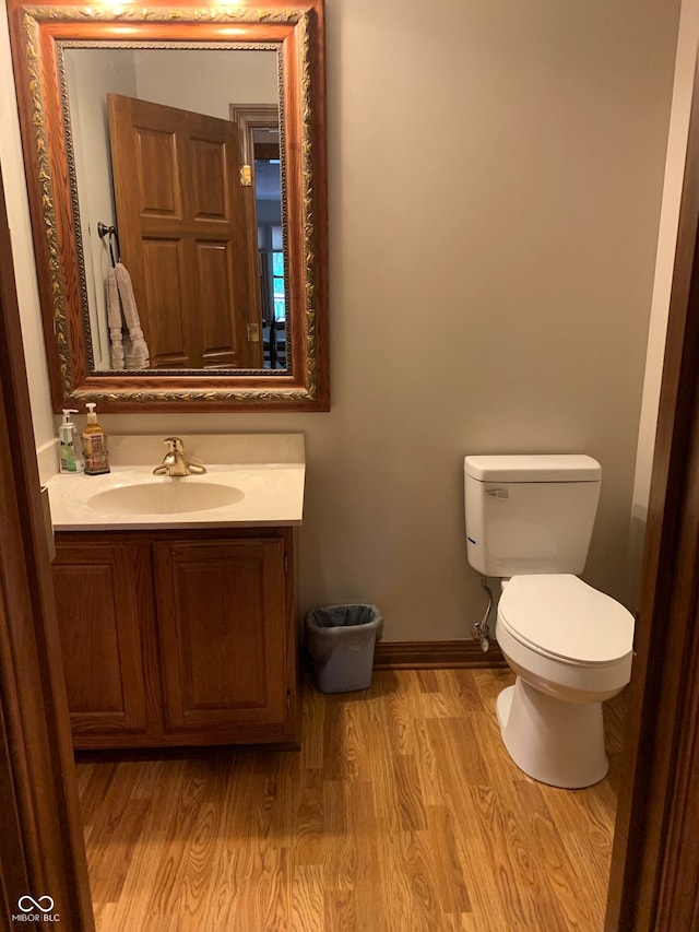 bathroom with wood-type flooring, toilet, and vanity