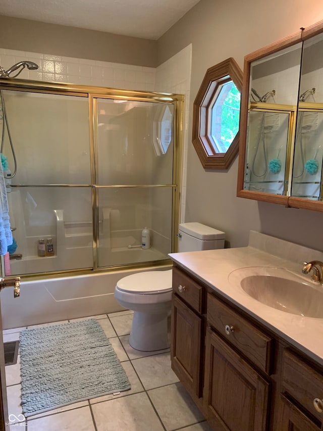 full bathroom featuring enclosed tub / shower combo, tile patterned floors, toilet, and vanity