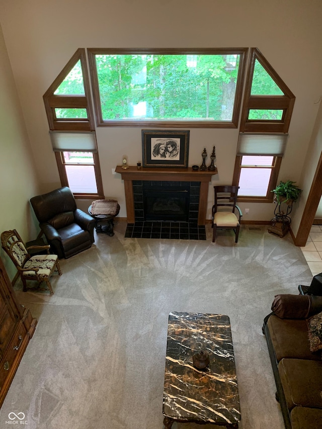 carpeted living room with a tiled fireplace and a wealth of natural light