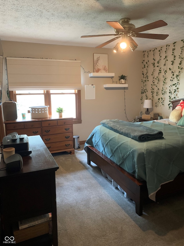 bedroom with ceiling fan, a textured ceiling, and carpet flooring